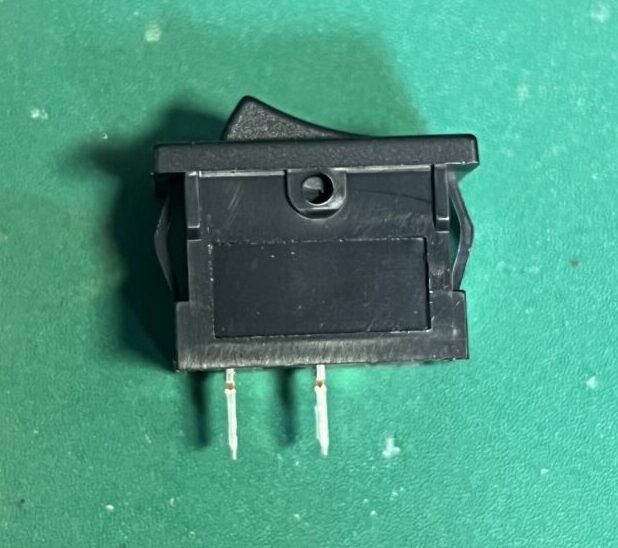 ロッカースイッチの側面写真。パネルマウントの爪と、半田端子が見える