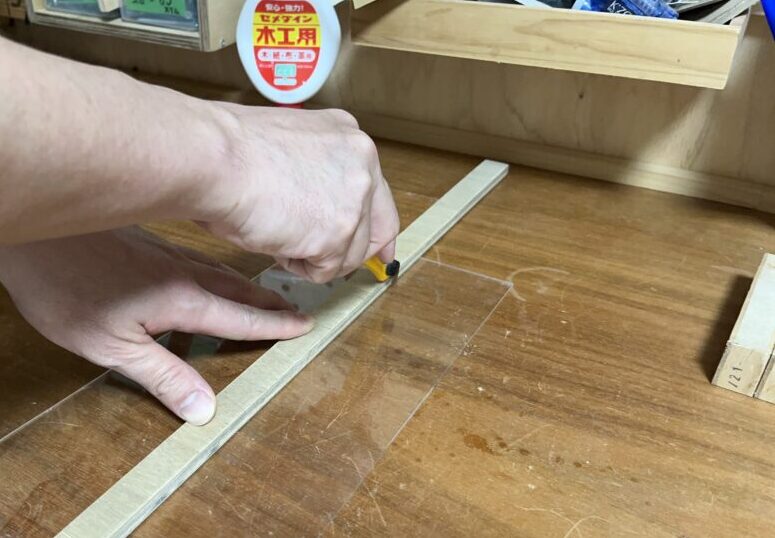 アクリル板をまっすぐ切るときはあてぎを定規代わりにして、少しずつアクリルカッターで切る。