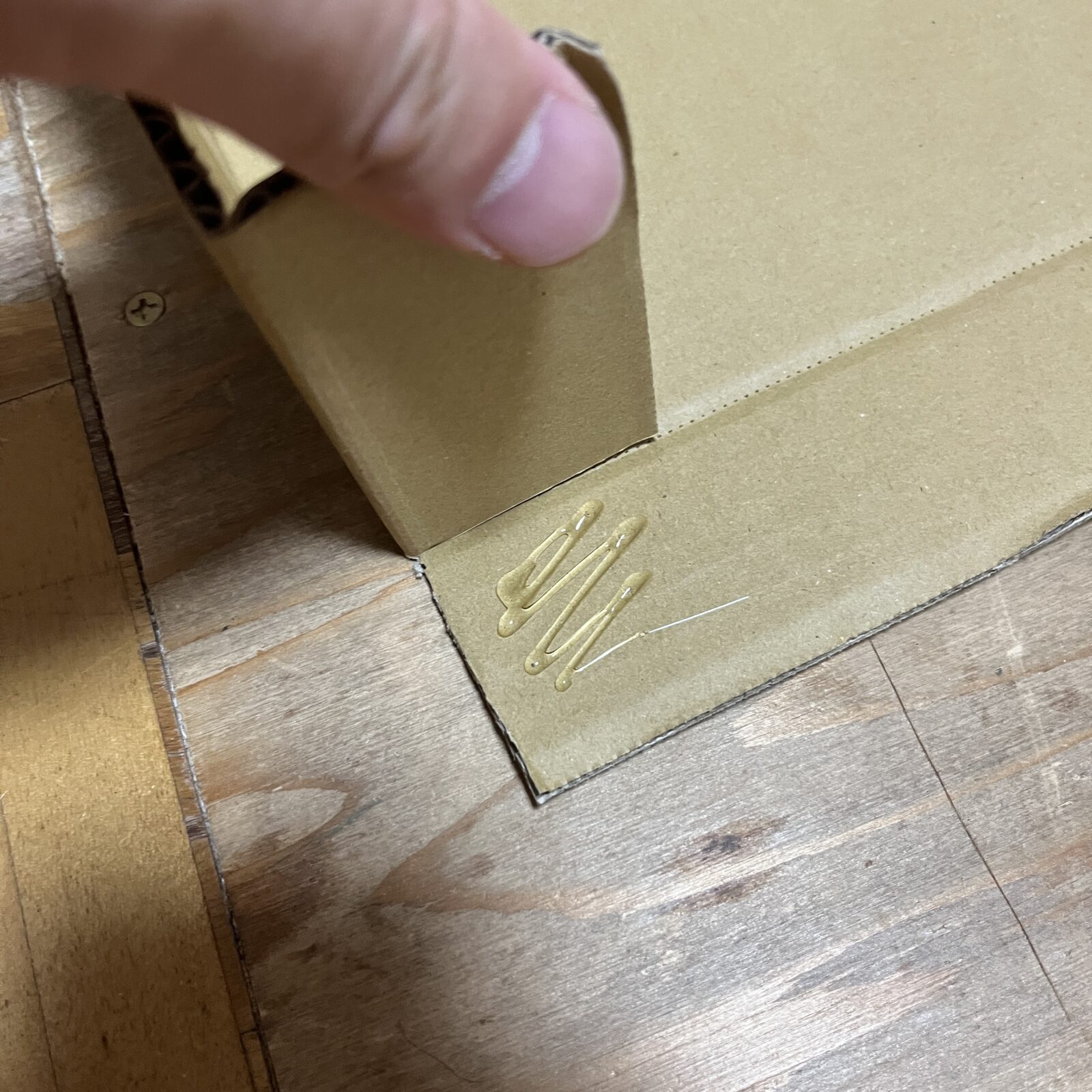 ダンボールを折り曲げてグルーガンで接着する
