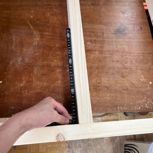 2x4で作った幕板の直角を金尺で確認している写真。