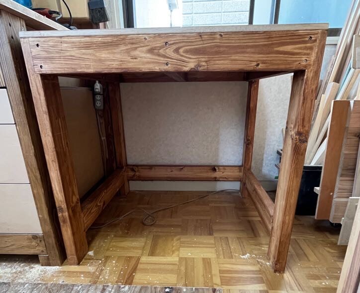 2x4で作った机の脚元の写真。貫に棚板を置けて収納力もある。